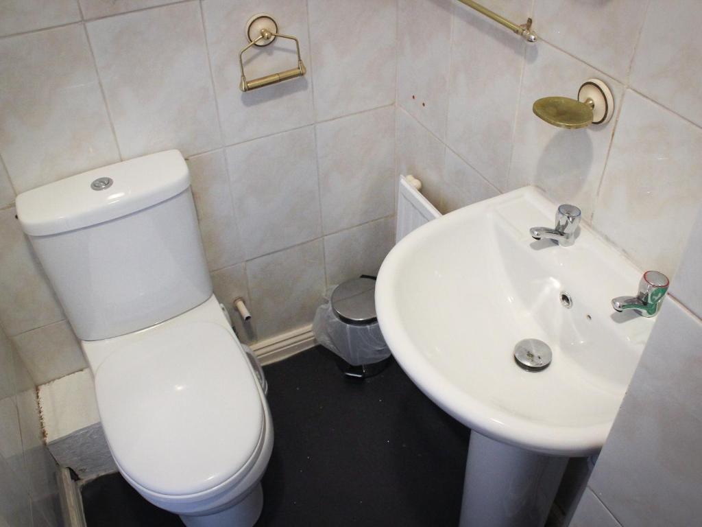 a bathroom with a white toilet and a sink at Mary House 46 in Porthcawl