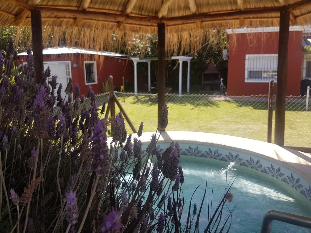 una bañera de hidromasaje en un patio con flores púrpuras en las moraditas en Chascomús