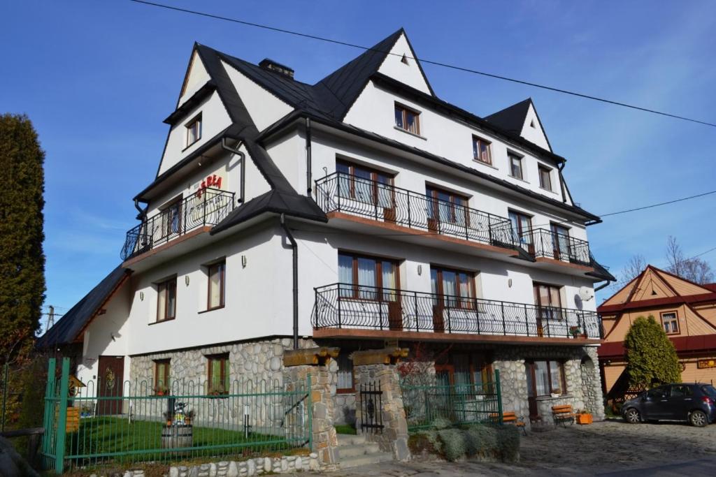 a large white house with a black roof at PERŁA in Białka Tatrzanska