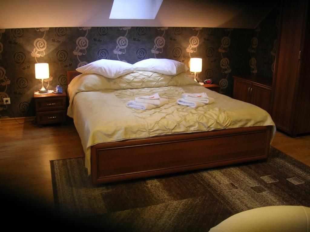 sypialnia z łóżkiem z ręcznikami w obiekcie Hotelik Gościniec Pod Sosnami Drzonków w Zielonej Górze