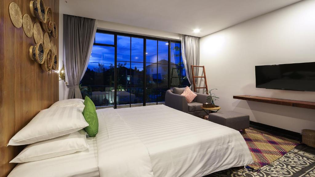 a bedroom with a large bed and a large window at Vihara The City of Temples in Siem Reap