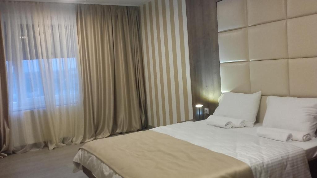 a hotel room with a bed and a window at Guesthouse Nikolić in Negotin