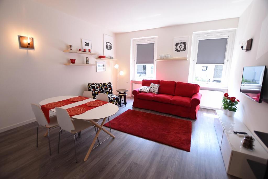 a living room with a red couch and a table at Le Rondinelle in Como
