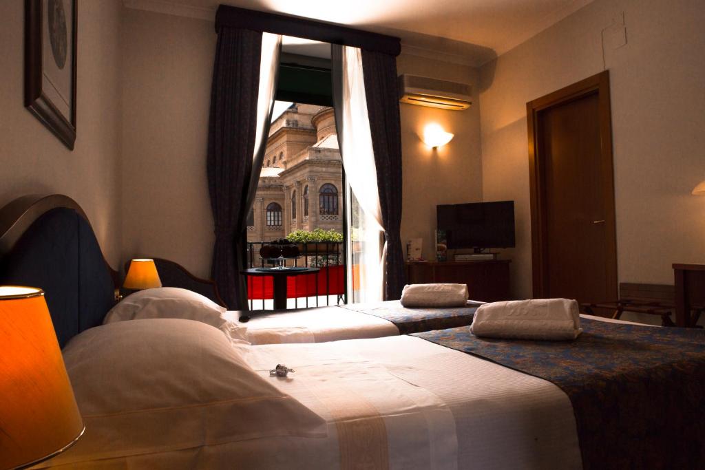 two beds in a room with a window at Massimo Plaza Hotel in Palermo