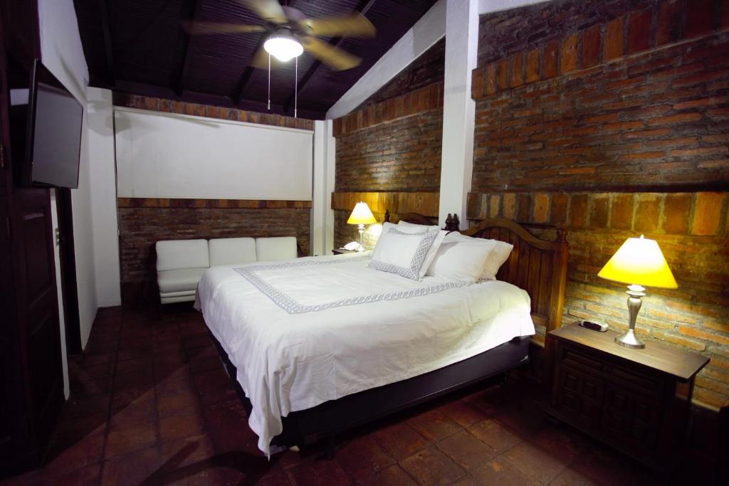 a bedroom with a bed and a brick wall at Hotel Casa Colonial Boutique in Managua