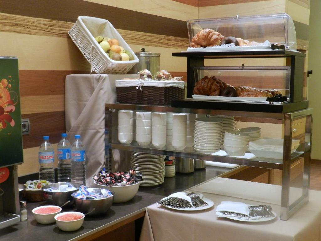 a table with plates and food on a shelf at Hotel Río Hortega in Valladolid