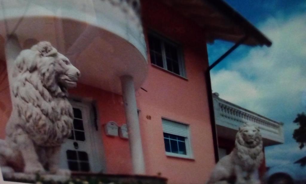 un edificio con una estatua de león delante de él en Angelina, en Baiersbronn