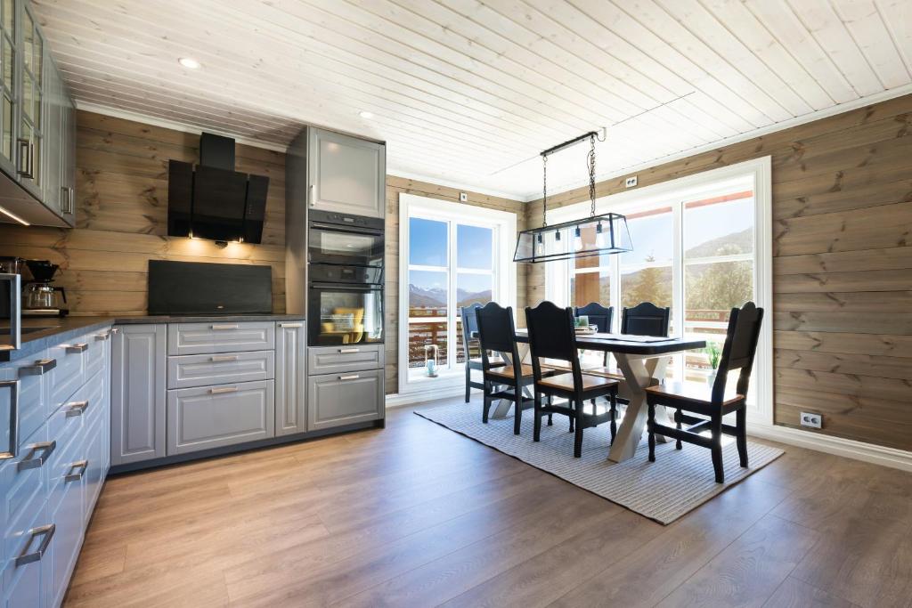 uma cozinha e sala de jantar com mesa e cadeiras em Lastølen 3 bedrooms em Brunstad