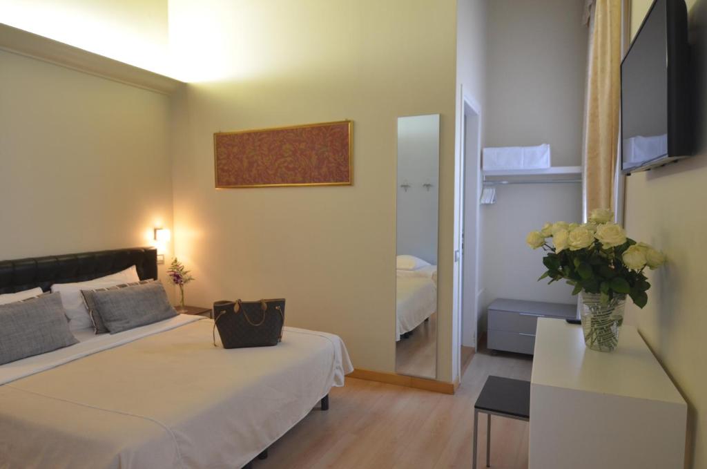 una camera d'albergo con due letti e uno specchio di Albergo al Tiepolo a Venezia