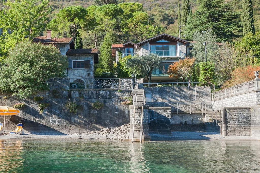 a house on the shore of a body of water at Villa Sara Lakeside in Oliveto Lario