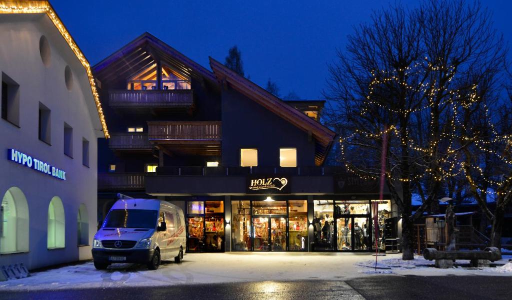 een busje geparkeerd op een parkeerplaats voor een gebouw bij Landhaus Antonia in Seefeld in Tirol