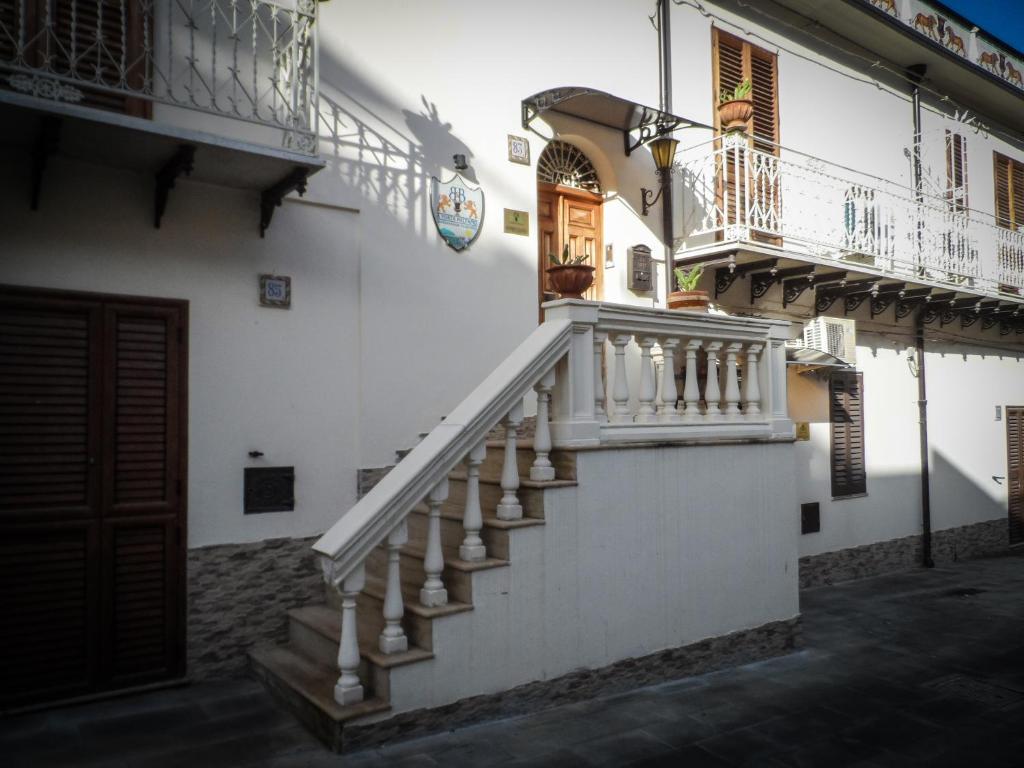 een wit gebouw met een trap en een balkon bij Guest House a Portapalermo in Santo Stefano di Camastra