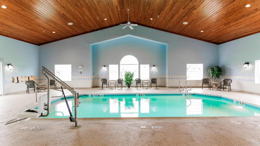 a pool in a large room with a wooden ceiling at Van Buren Hotel in Shipshewana