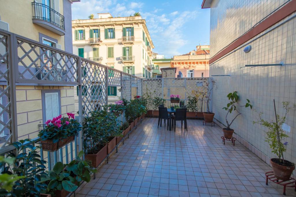 einen Balkon mit einem Tisch, Stühlen und Gebäuden in der Unterkunft Salerno e le due coste in Salerno