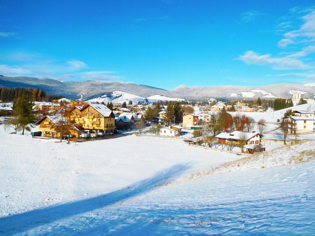 una pequeña ciudad en la nieve con casas en Hotel Vescovi en Asiago