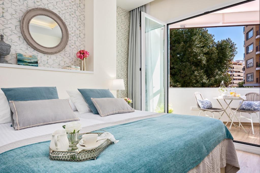 ein Schlafzimmer mit einem großen Bett und einem großen Fenster in der Unterkunft iloftmalaga Centro Alameda in Málaga