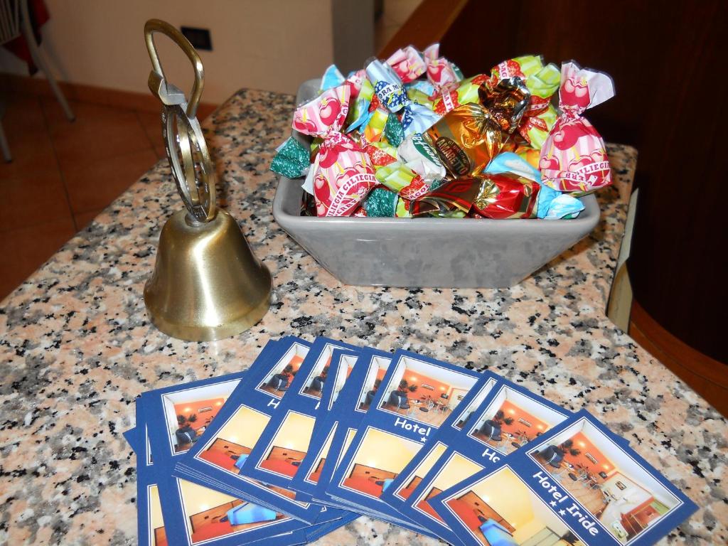 un tavolo con una ciotola di caramelle e un campanello di Hotel Iride stazione Lambrate Città studi a Milano