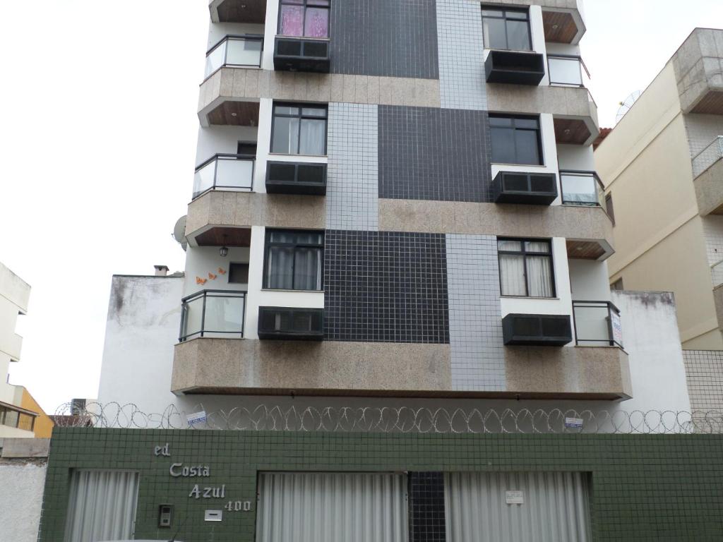 un edificio alto con azulejos blancos y negros. en Apartamento Temporada Praia do Morro, en Guarapari