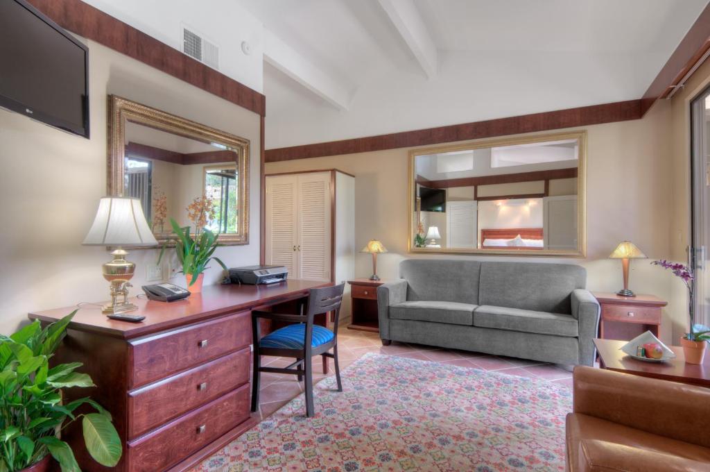 a living room with a desk and a chair and a couch at Dinah's Garden Hotel in Palo Alto