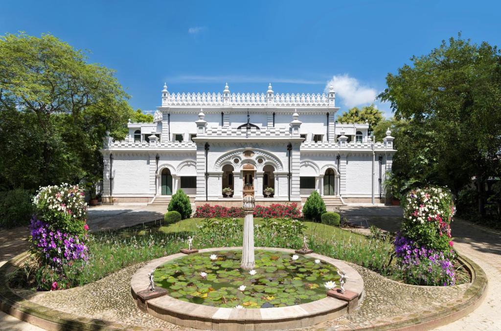 a large white house with a pond in front of it at Nivah in Morādābād