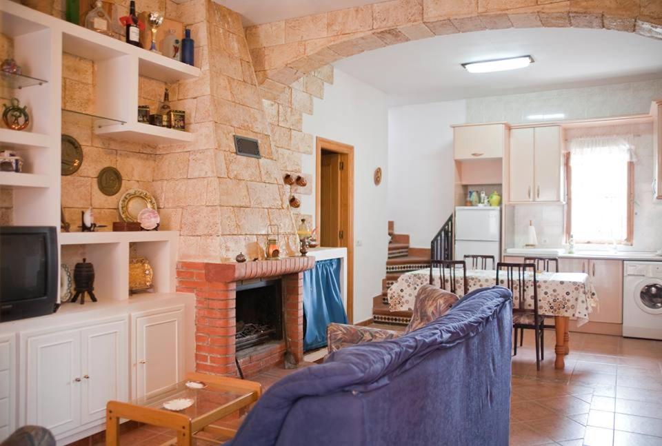 Vivienda Rural El Mirador de Enix في Enix: غرفة معيشة مع أريكة زرقاء ومدفأة