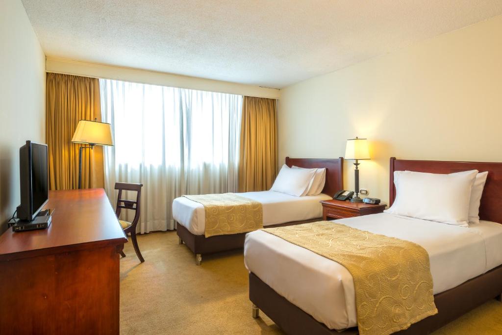 Postel nebo postele na pokoji v ubytování Hotel Dann Av. 19