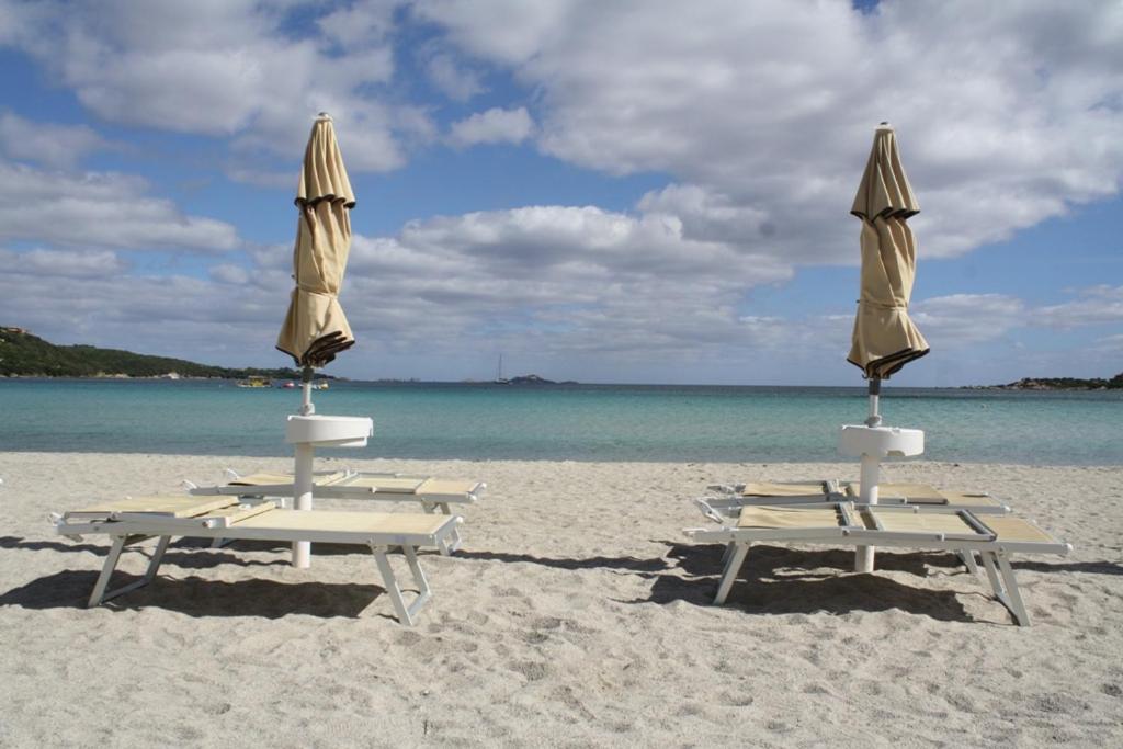 2 ligstoelen en parasols op het strand bij Casa Gallo in Marinella