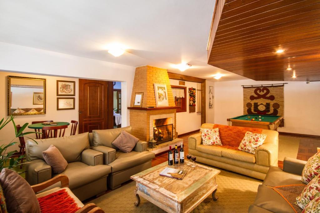 sala de estar con sofás y mesa de billar en Pousada Serena, en Campos do Jordão