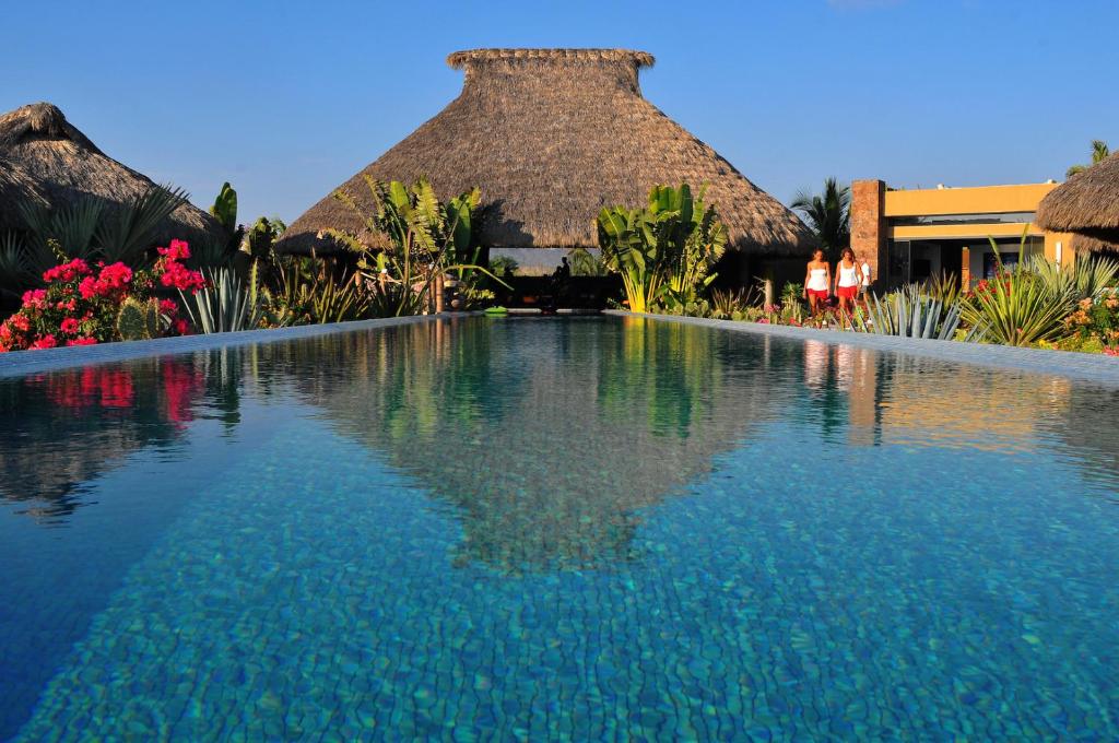 a swimming pool in front of a resort at Samora Luxury Resort in Santa María Colotepec