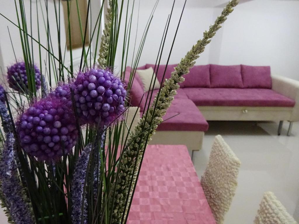 a living room with purple flowers and a couch at Jasmin White Apartment in Skopje