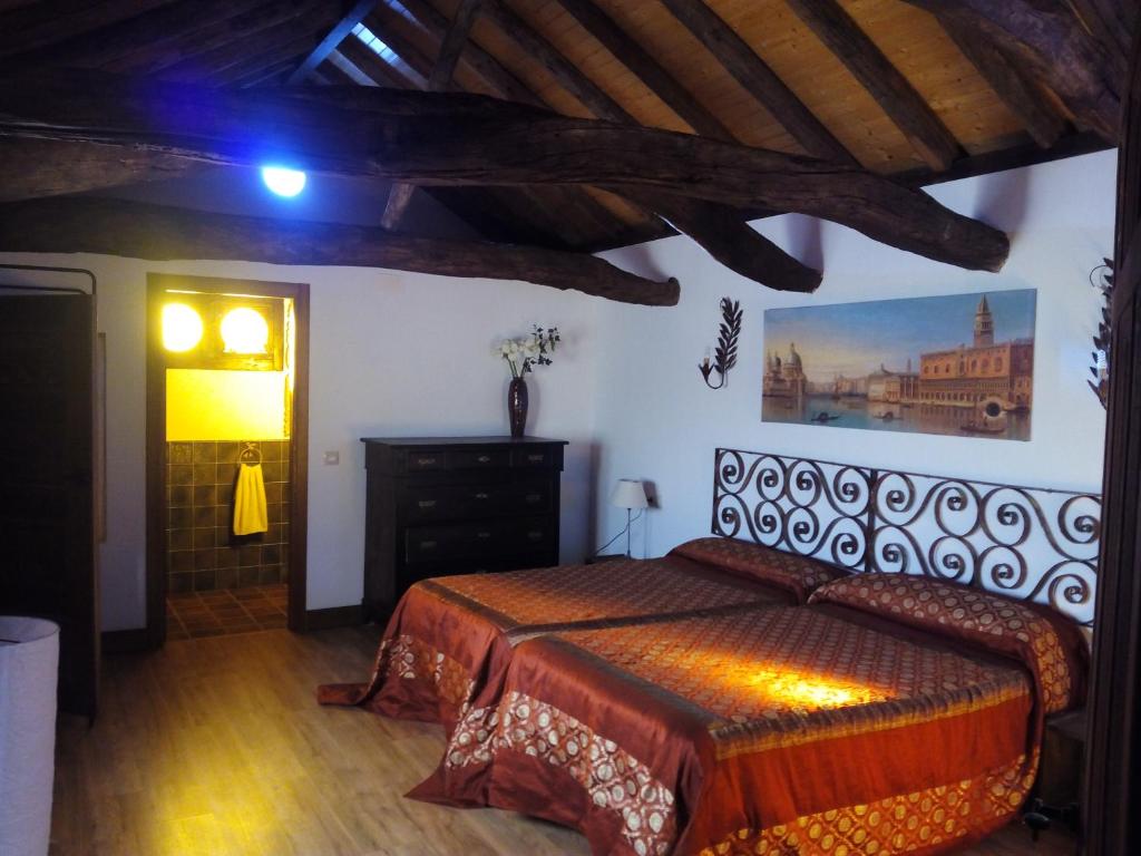 a bedroom with a bed and a painting on the wall at El Sueño de Lucrecia in Villarrubia de Santiago