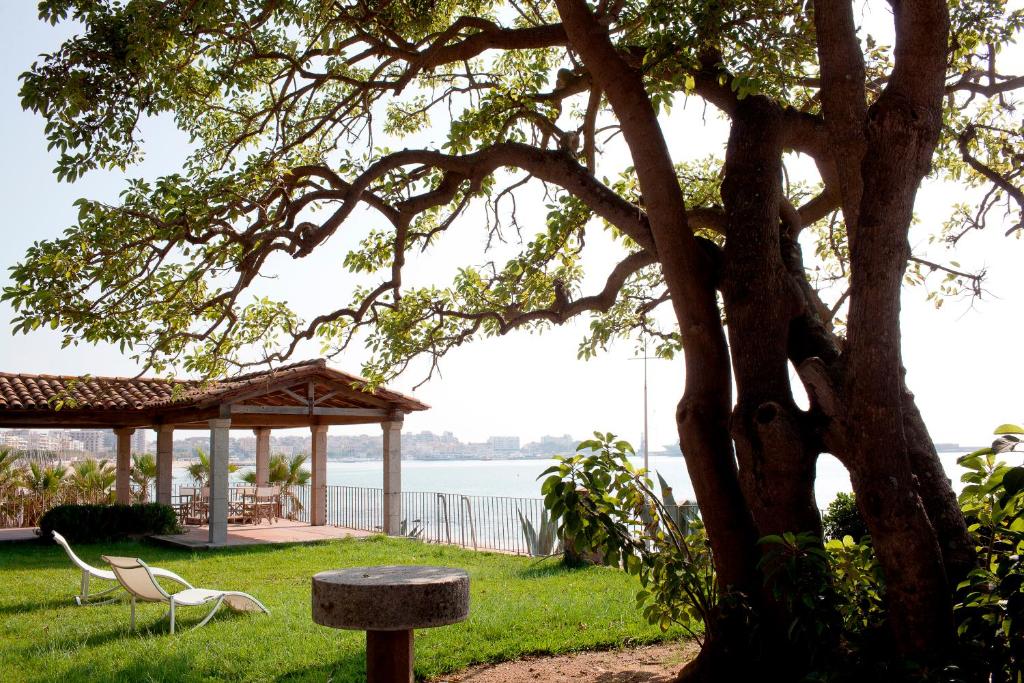 ein Picknicktisch und ein Pavillon neben einem Baum in der Unterkunft ÀNCORA VELLA in Sant Antoni de Calonge