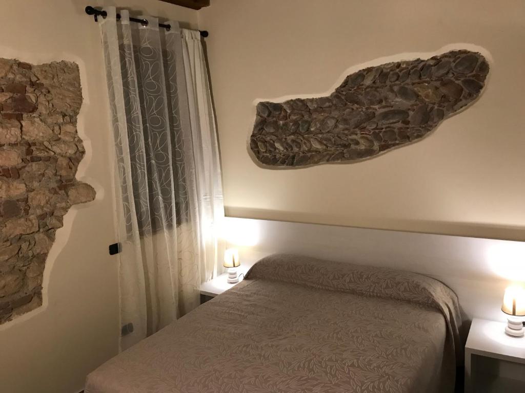 ヴェローナにあるSciesa24のベッドルーム1室(ベッド1台付)、壁にキャンドル2本が備わります。