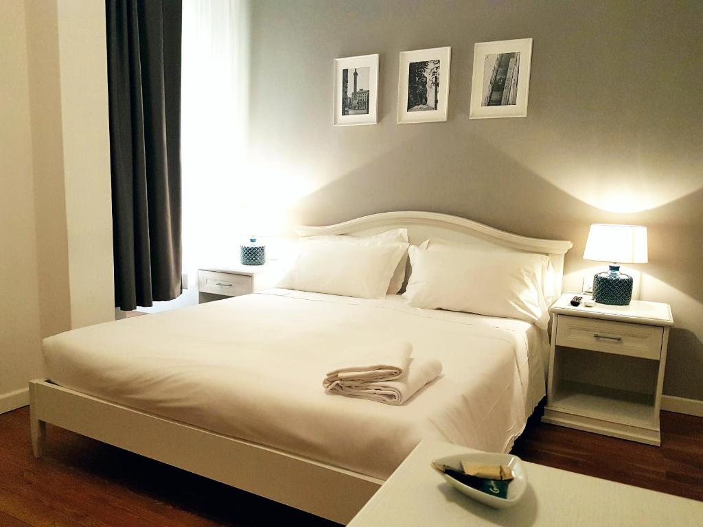 um quarto com uma cama branca e uma mesa em More Cola di Rienzo B&B em Roma