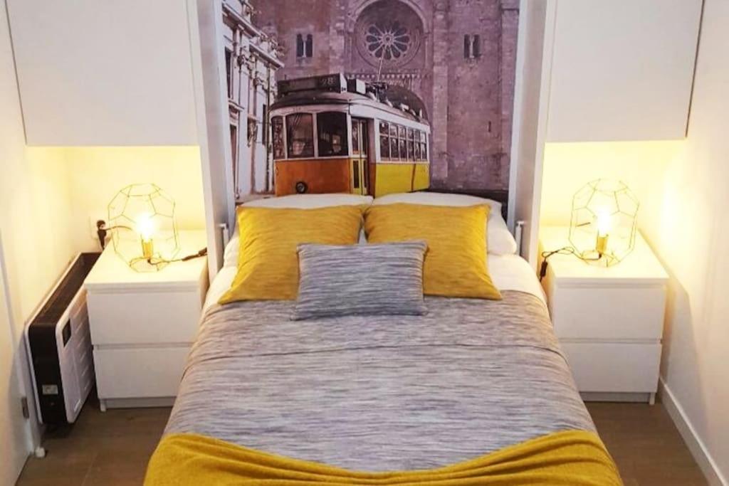 1 dormitorio con 1 cama grande con almohadas amarillas en Studio 63 Historic Center, en Lisboa