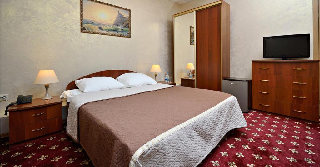 モスクワにあるRus Hotelのベッド1台、薄型テレビが備わるホテルルームです。