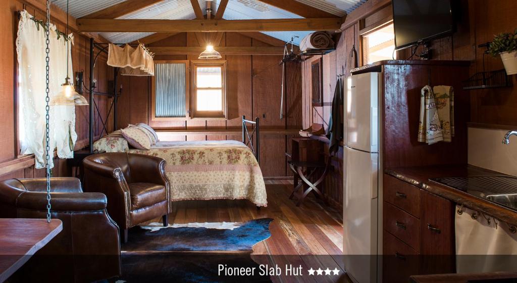 a kitchen with a refrigerator and a bed in a room at Saltbush Retreat in Longreach