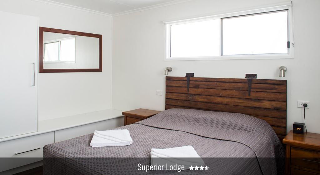 a bedroom with a bed and two windows at Saltbush Retreat in Longreach