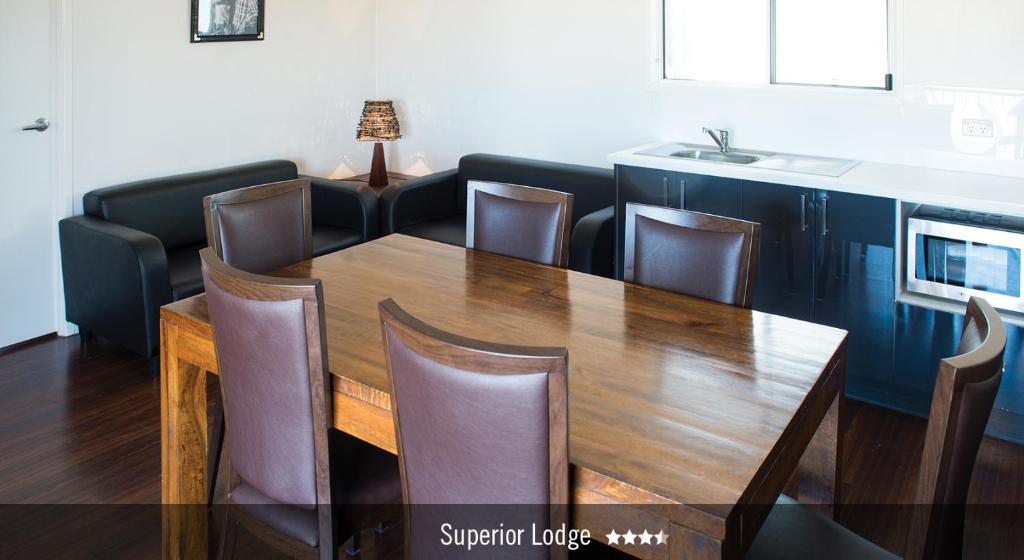 a dining room with a wooden table and chairs at Saltbush Retreat in Longreach