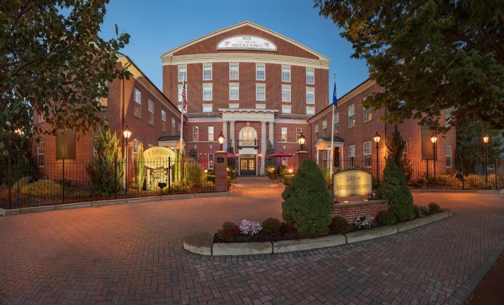 a large brick building with a clock on top of it at Inn at Middletown in Middletown