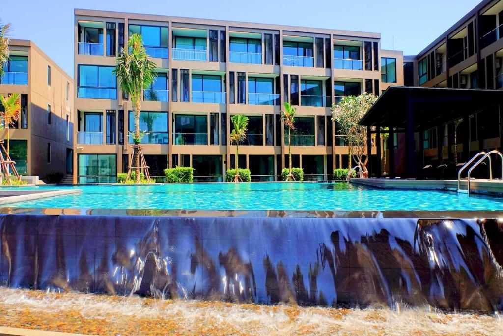 a large swimming pool in front of a building at Pixels Condo Unit 261 in Panwa Beach