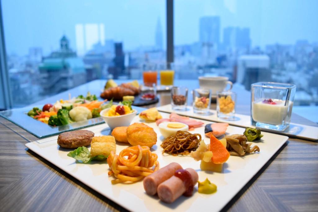 a table with several plates of food on it at Shinjuku Granbell Hotel in Tokyo