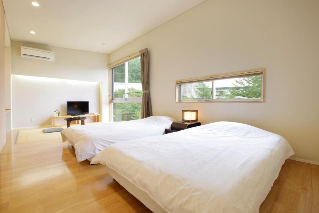 Postel nebo postele na pokoji v ubytování Kusatsu Hotel Bekkan Wata no Yu (Adult Only)