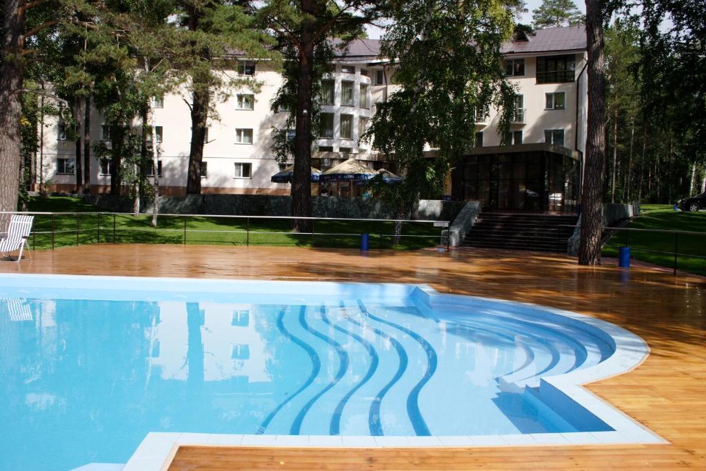 una piscina in un parco con un edificio sullo sfondo di MOROZOVO Resort-Hotel&SPA a Berdsk