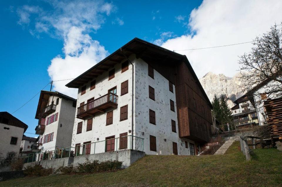 a white building with a balcony on the side of it at Appartamenti Royal in San Vito di Cadore