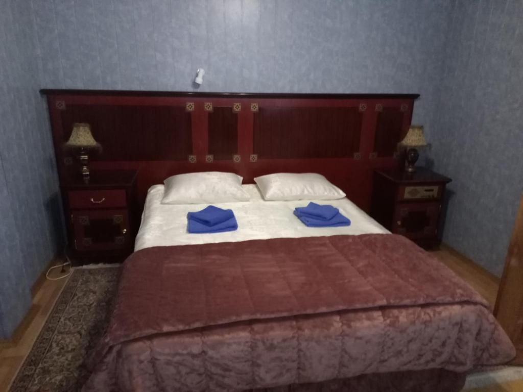 a bedroom with a large bed with blue towels on it at Dom Artistov Tsirka Arena Tula in Tula