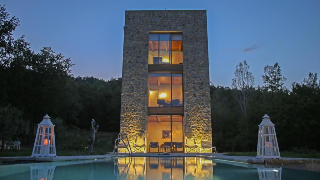 a building with a swimming pool in front of it at Torre dei Sogni in Poppi