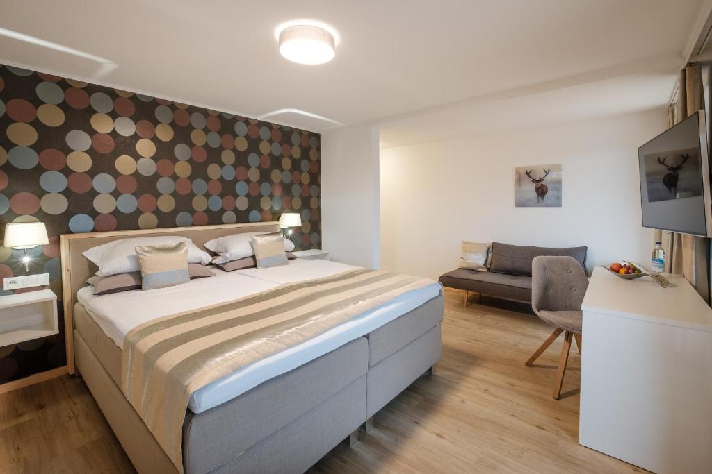 um quarto com uma cama grande e um sofá em bichl 761 em Fischen