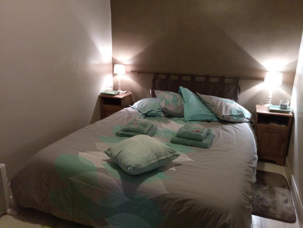 a bedroom with a bed with pillows on it at Lougat la maison des chats in Cordes-sur-Ciel