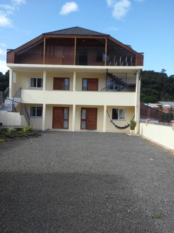 a large house with a large driveway in front of it at Flat Theobald in Três Coroas